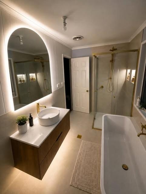 Bathroom renovation with backlit mirror and vanity lighting