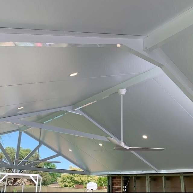 Vaulted patio ceiling with installed fans and downlights